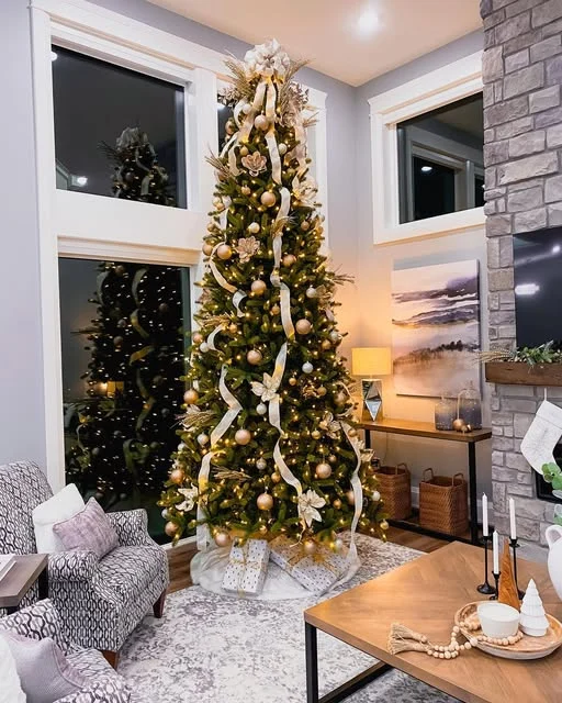 Christmas tree with warm lights and ribbon beside a stone fireplace